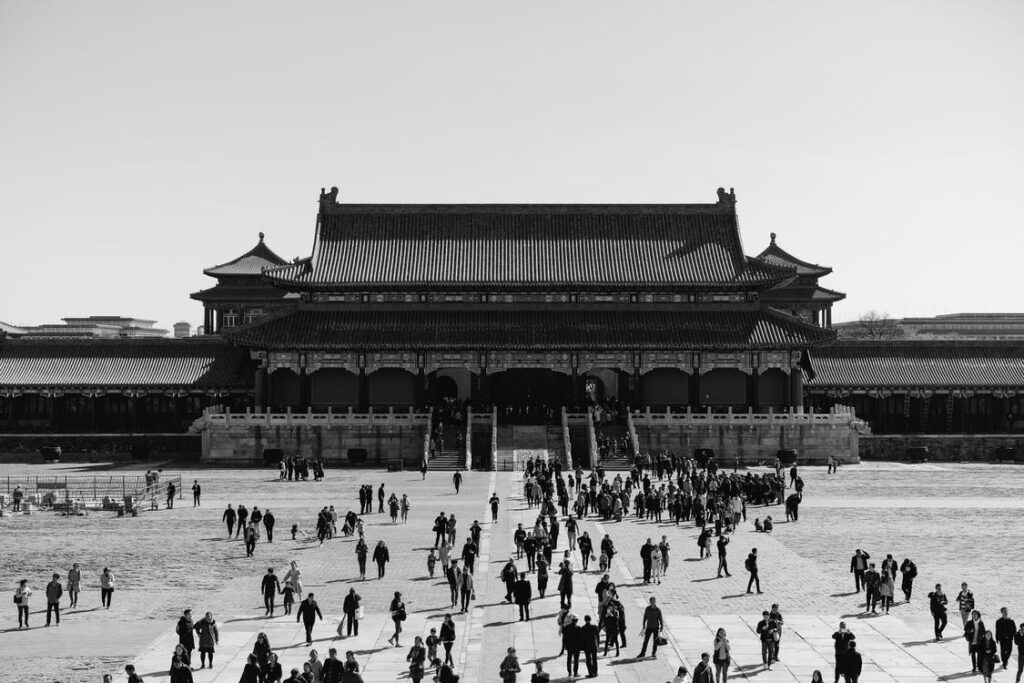 foto em preto e branco de um templo chines ao fundo e varios turistas indo em direcao a ele