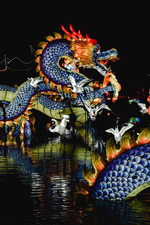 um grande dragao azul sobre um lago durante um dos festivais chineses